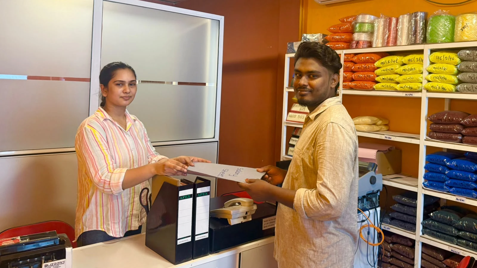 Mundiyan office staff assisting a customer with documents